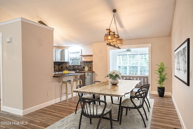 dining room featuring a textured ceiling, ceiling fan, dark wood-type flooring, and sink