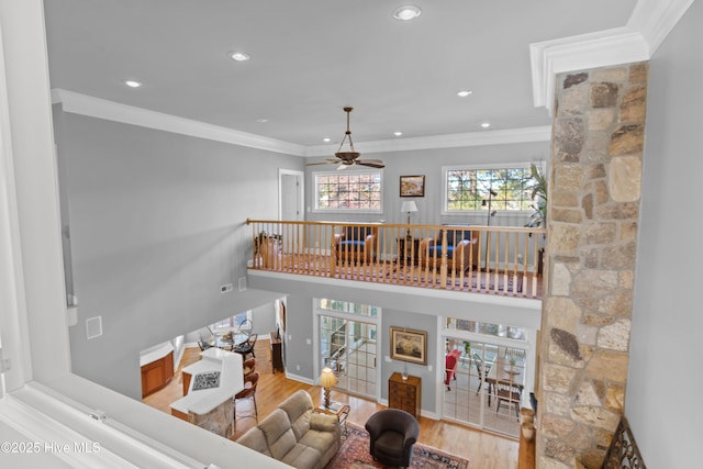 living area featuring ceiling fan, recessed lighting, wood finished floors, baseboards, and ornamental molding