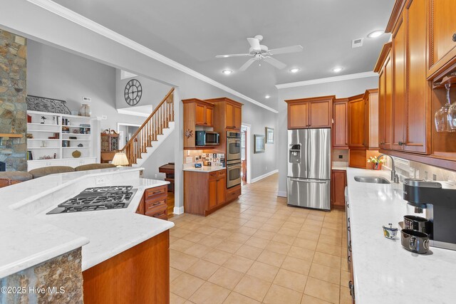 kitchen with crown molding, appliances with stainless steel finishes, hanging light fixtures, and backsplash