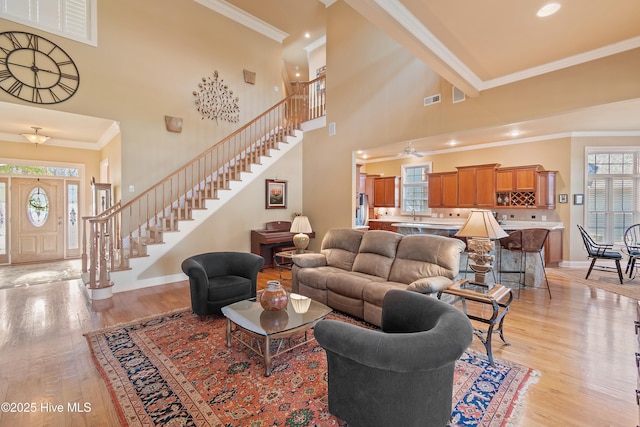 living area featuring visible vents, stairs, and a wealth of natural light
