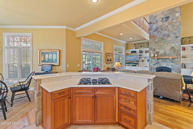 kitchen with crown molding, light stone counters, light wood-type flooring, stainless steel appliances, and decorative backsplash