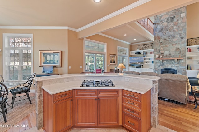 kitchen featuring a fireplace, open floor plan, and ornamental molding