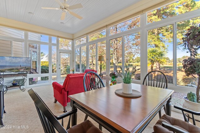 sunroom with a wall mounted AC and ceiling fan