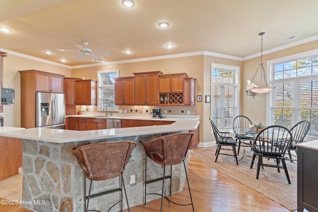kitchen featuring stainless steel appliances, backsplash, visible vents, a sink, and brown cabinetry