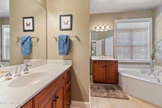 bathroom with vanity, a bath, and tile patterned floors