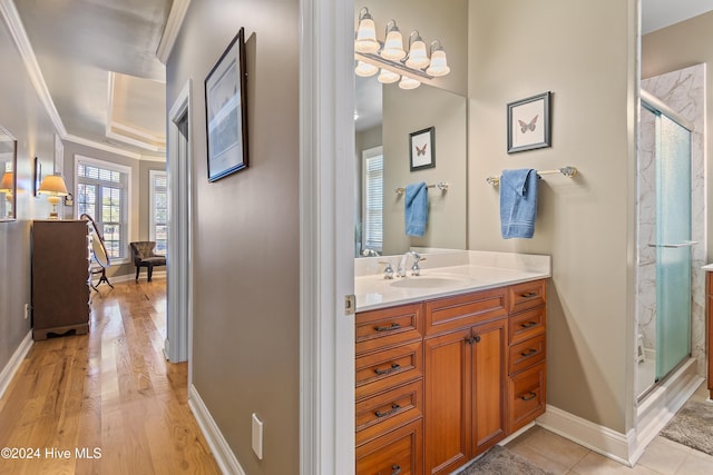 full bath featuring a stall shower, crown molding, vanity, and baseboards