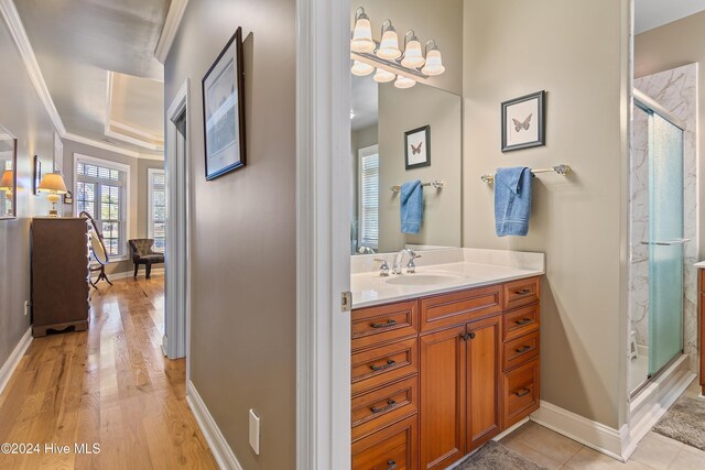 bathroom featuring an enclosed shower, vanity, and ornamental molding