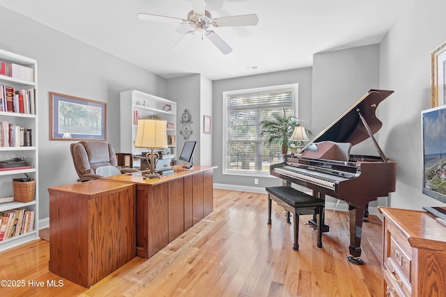 office space featuring light wood-style floors, ceiling fan, visible vents, and baseboards