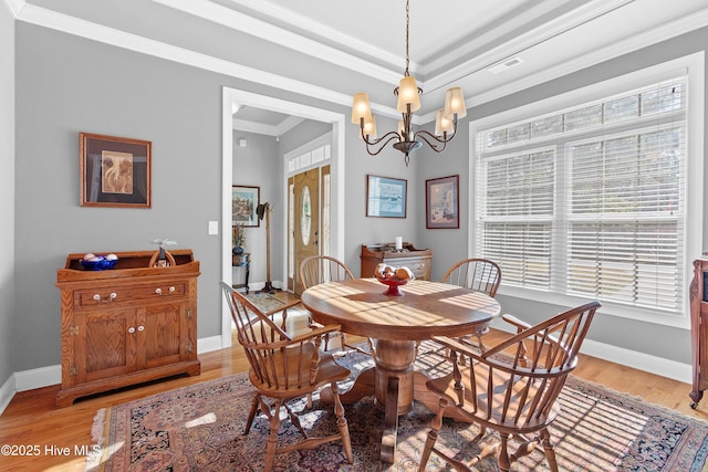 dining area with baseboards, light wood finished floors, visible vents, and crown molding