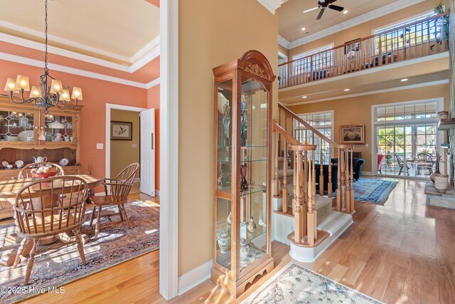 interior space with wood finished floors, baseboards, stairway, and crown molding