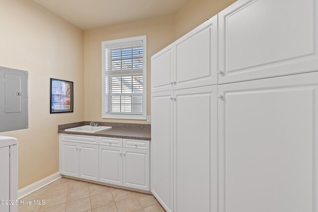 bathroom with tile patterned floors, vanity, electric panel, baseboards, and washer / clothes dryer