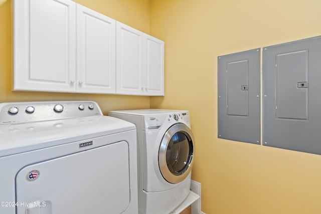 washroom featuring independent washer and dryer, cabinet space, and electric panel