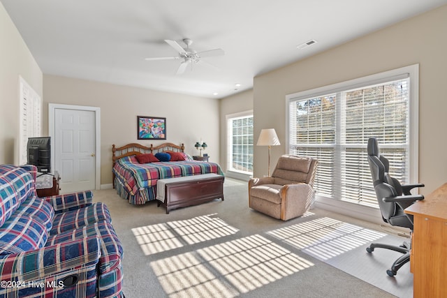 carpeted bedroom with baseboards, a ceiling fan, and visible vents