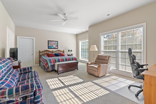 carpeted bedroom with visible vents and a ceiling fan