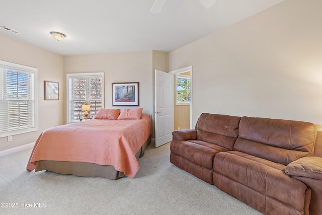 bedroom with light carpet, baseboards, visible vents, and a ceiling fan