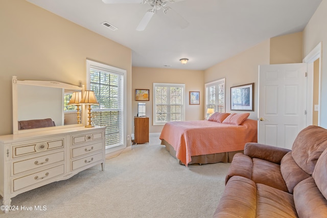 carpeted bedroom with a ceiling fan and visible vents