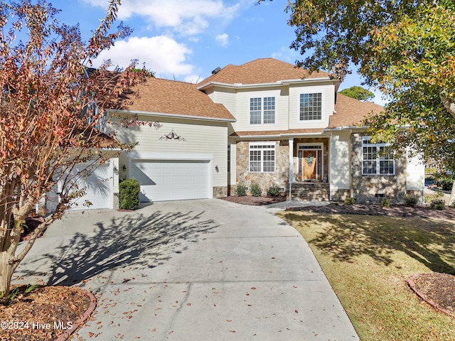 traditional-style home featuring an attached garage, stone siding, and concrete driveway