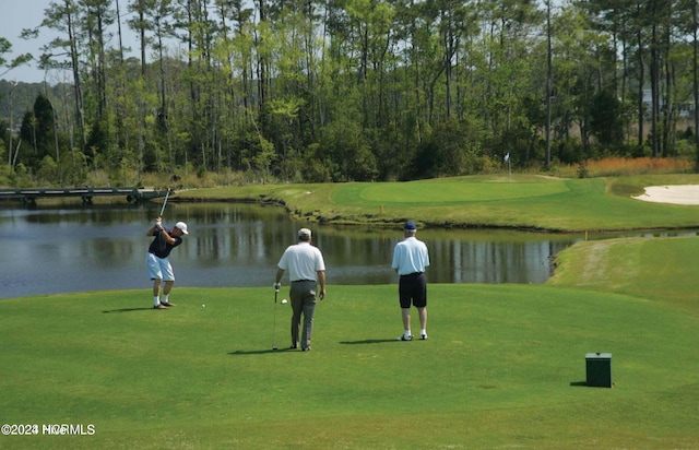 view of property's community featuring a yard, golf course view, and a water view