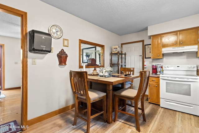 dining space featuring a textured ceiling and light hardwood / wood-style flooring