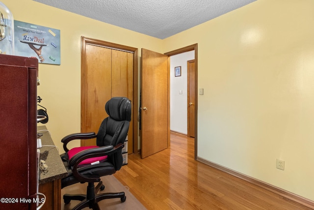 office area featuring light hardwood / wood-style floors and a textured ceiling