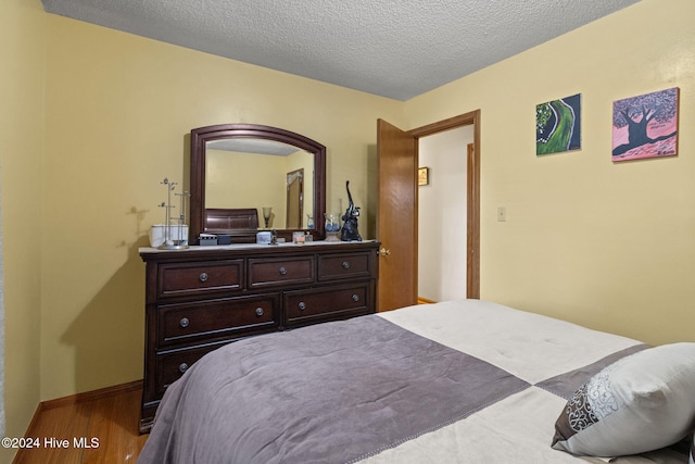 bedroom featuring a textured ceiling and hardwood / wood-style flooring