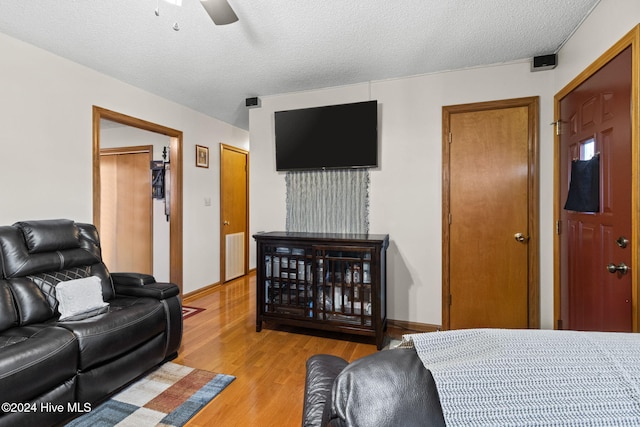 interior space with ceiling fan, a textured ceiling, and light hardwood / wood-style flooring