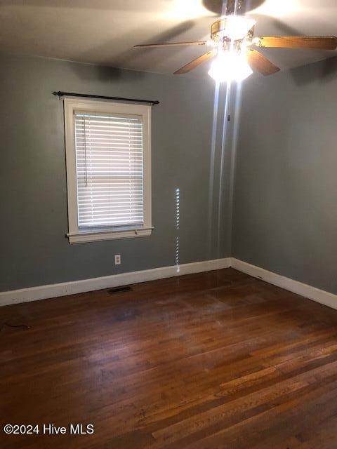 spare room featuring dark hardwood / wood-style floors and ceiling fan