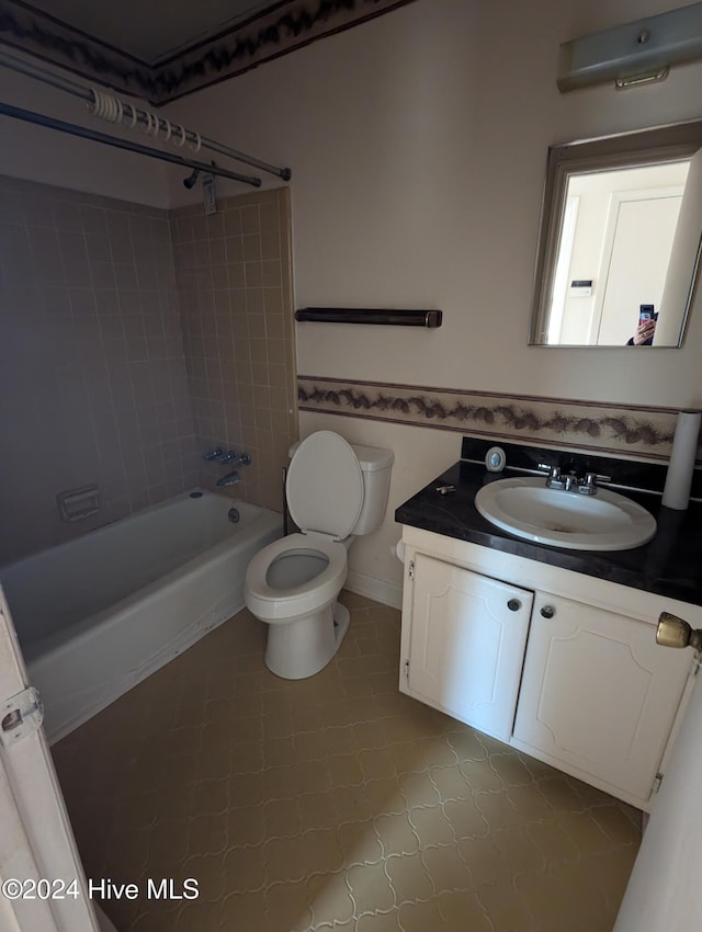 full bathroom featuring tile patterned flooring, vanity, toilet, and tiled shower / bath