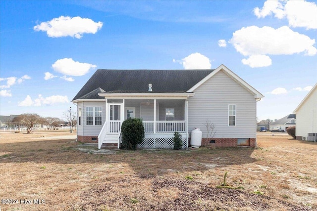 back of property featuring a porch, a yard, and cooling unit