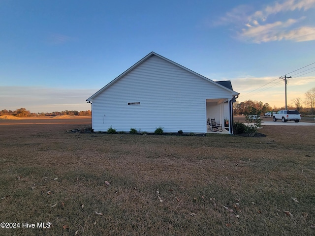 property exterior at dusk with a lawn