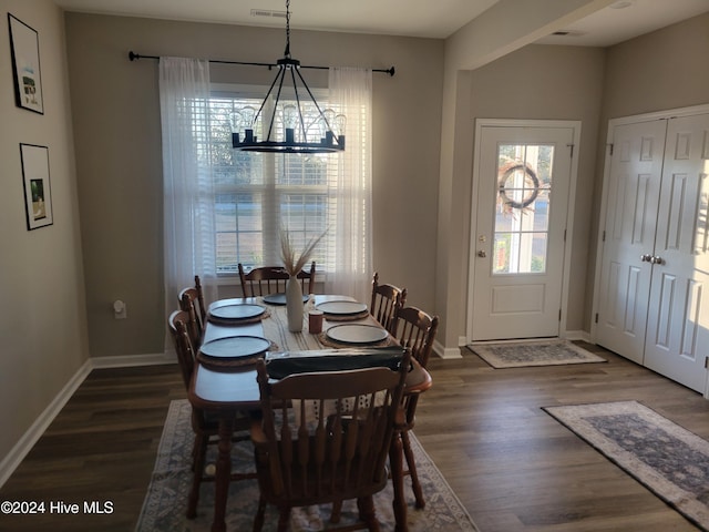 dining room with plenty of natural light, dark hardwood / wood-style floors, and an inviting chandelier