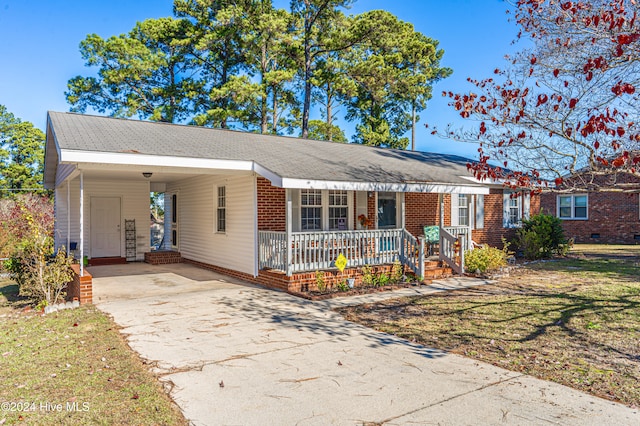 single story home featuring a front lawn, a porch, and a carport