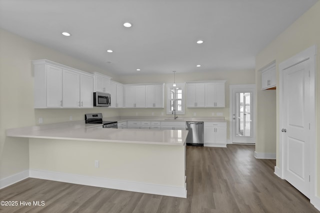 116 Talbert Dr, Rocky Point, NC 28457 - kitchen with appliances with stainless steel finishes, light countertops, wood finished floors, white cabinets, and recessed lighting