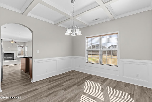 unfurnished dining area with beamed ceiling, ornamental molding, dark hardwood / wood-style flooring, and coffered ceiling