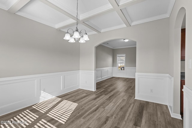 unfurnished dining area with coffered ceiling, dark hardwood / wood-style floors, ornamental molding, beamed ceiling, and a notable chandelier