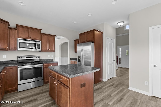 kitchen featuring a kitchen island, stainless steel appliances, and hardwood / wood-style flooring