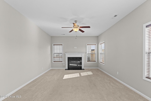 unfurnished living room featuring a wealth of natural light and light carpet