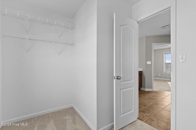 walk in closet with light tile patterned flooring