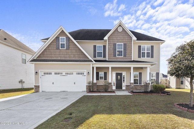 craftsman-style house featuring covered porch, a garage, and a front lawn