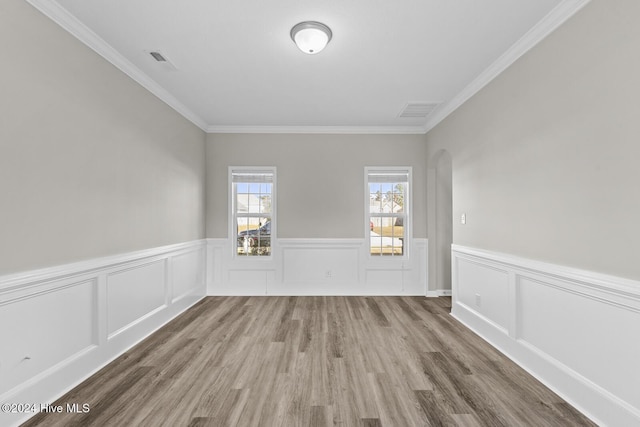 spare room with wood-type flooring and crown molding