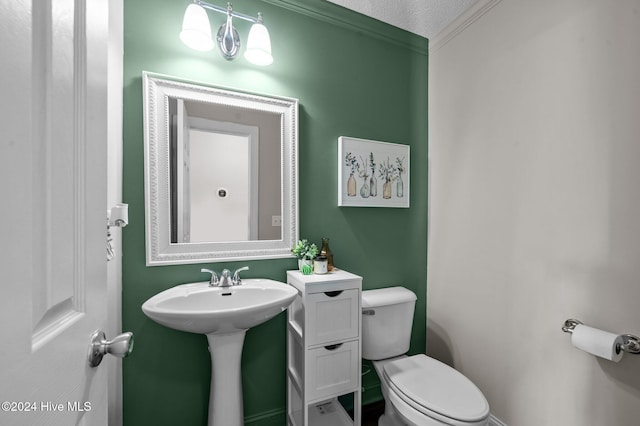 bathroom with toilet, a textured ceiling, and ornamental molding