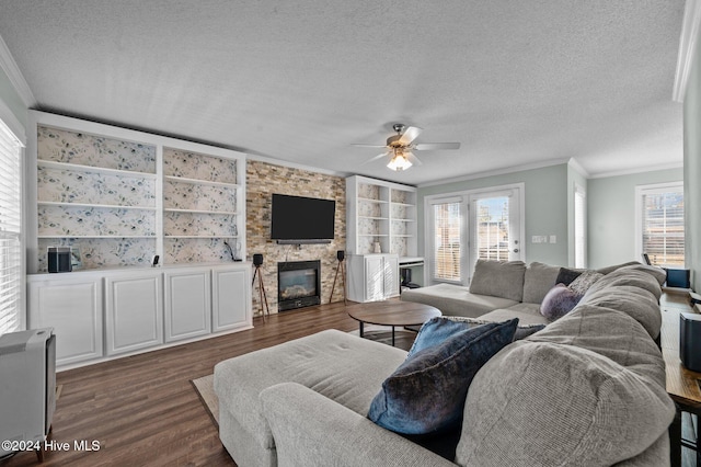 living room with ornamental molding, dark hardwood / wood-style flooring, a fireplace, a textured ceiling, and built in features