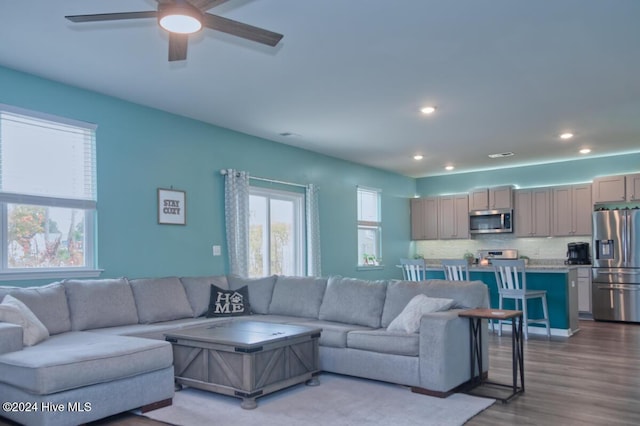 living room with light hardwood / wood-style floors and ceiling fan