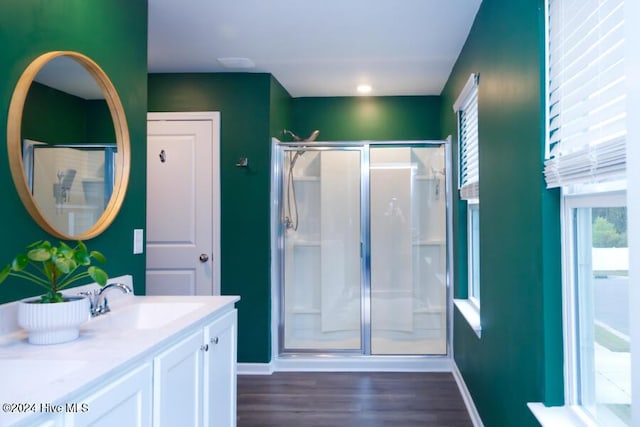 bathroom featuring a shower with door, hardwood / wood-style floors, and a wealth of natural light