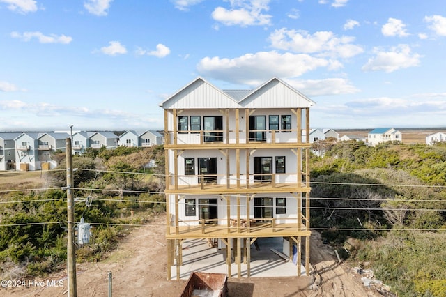 view of front of property featuring a balcony and a carport