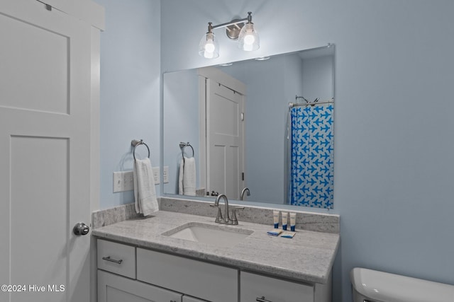 bathroom featuring a shower with curtain, vanity, and toilet