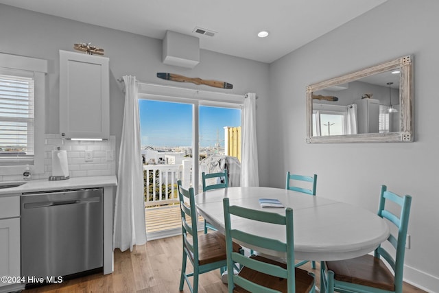 dining space featuring light wood finished floors, recessed lighting, visible vents, and plenty of natural light