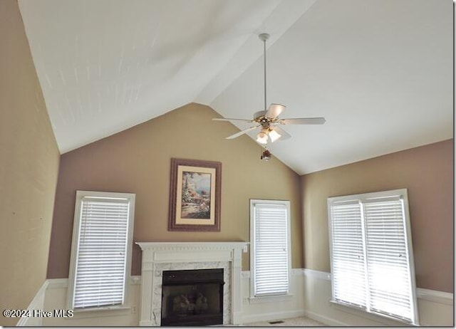 unfurnished living room featuring ceiling fan, a high end fireplace, and vaulted ceiling