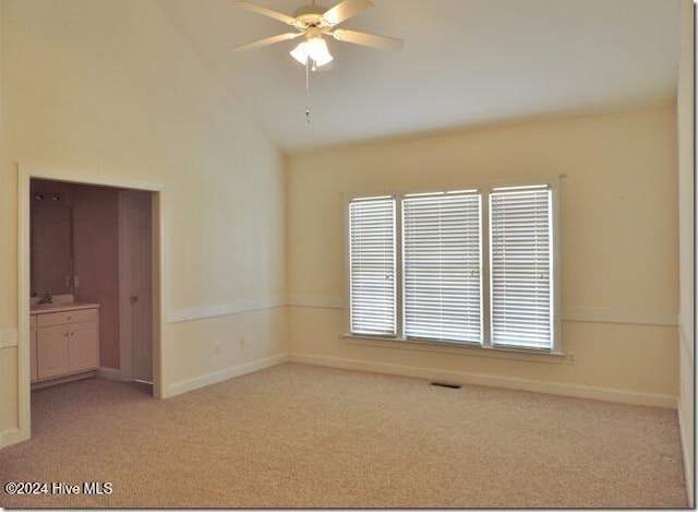 carpeted empty room featuring ceiling fan and lofted ceiling