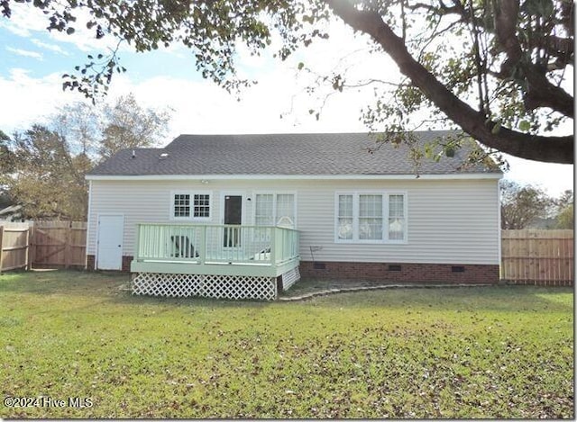 rear view of house with a wooden deck and a yard